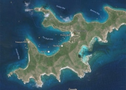 Satellite view of Norman Island, British Virgin Islands, showing bays, anchor points, and surrounding waters.