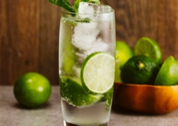 Refreshing mojito cocktail with lime slices and mint garnish, perfect for a summer sail.