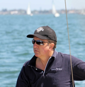 NauticEd instructor Mark Noneman sailing at the helm