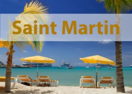 Saint Martin tropical beach scene with palm trees, yellow umbrellas, and boats on turquoise water. Perfect vacation spot.