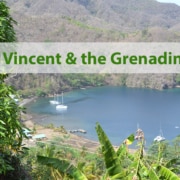 Scenic view of St. Vincent and the Grenadines bay with anchored sailboats and lush green landscape.