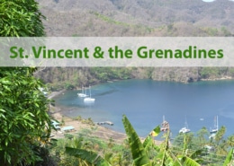 Scenic view of St. Vincent and the Grenadines bay with anchored sailboats and lush green landscape.