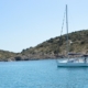 Sailboat anchored in serene blue water near rocky coast, ideal for sailing adventures and peaceful escapes.