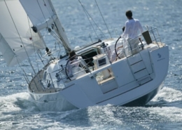 Sailboat with people navigating open waters, capturing the essence of adventure and freedom under clear skies.