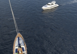 Sailboat and motor yacht on open sea, aerial view, showcasing a serene maritime adventure on calm waters.