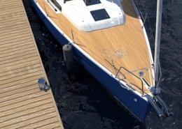 Aerial view of a sailboat with a wooden deck moored at a dock, floating on calm, dark blue water.