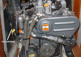 Sailboat engine with labeled oil dipstick and water pump, showcasing essential maintenance points.