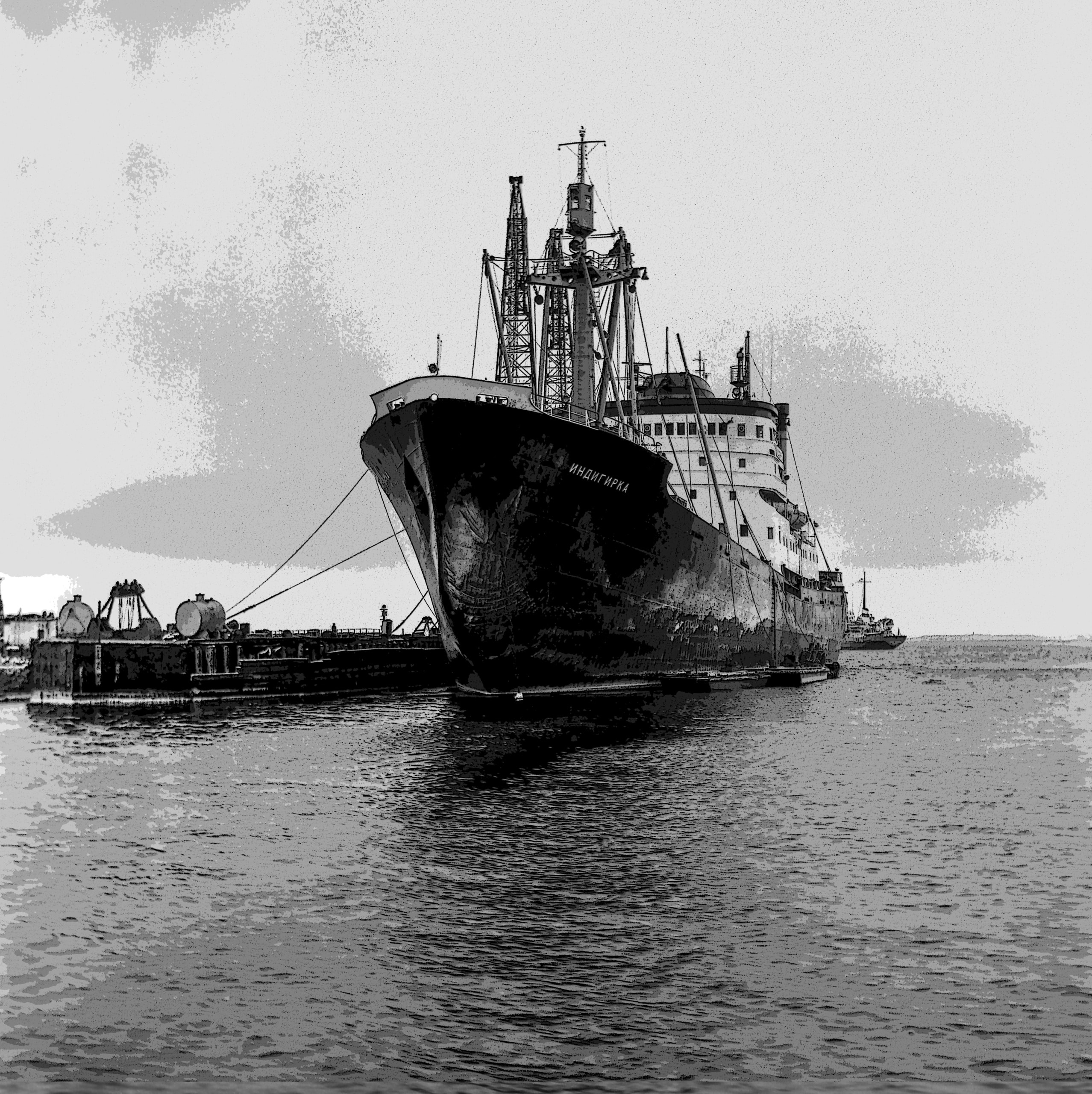 Large ship docked at a harbor, preparing for a maritime journey against a serene, overcast sky.