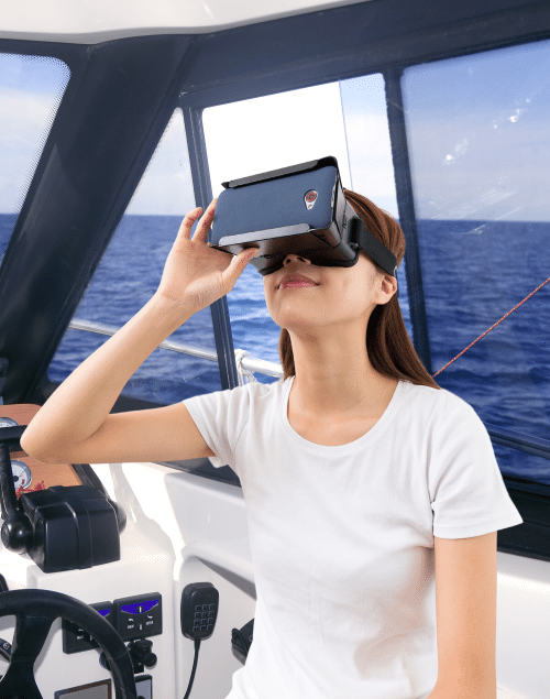 Person experiencing virtual reality sailing adventure on a boat, wearing VR headset, with open ocean view through the window.