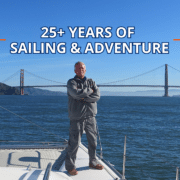 Man standing on sailboat with Golden Gate Bridge in the background, celebrating 25+ years of sailing adventure.