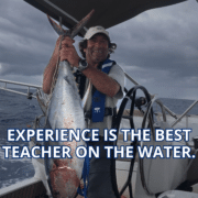 Sailor proudly holds a large fish on a yacht, showcasing a maritime catch under cloudy skies. Text: Experience is the Best Teacher.