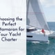 Catamaran sailing on open sea under blue sky with text: Choosing the Perfect Catamaran for Your Yacht Charter.