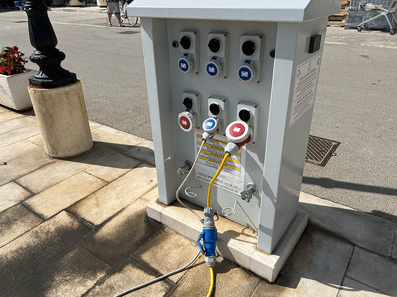 Marina power pedestal with electrical outlets for boat charging and utilities.