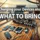 Devices charging on a sailboat deck with a solar panel, illustrating what to bring for tech convenience while sailing.