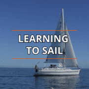 Sailboat on calm blue sea under clear sky, Learning to Sail text overlay.