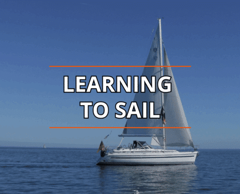 Sailboat on calm blue sea under clear sky, Learning to Sail text overlay.