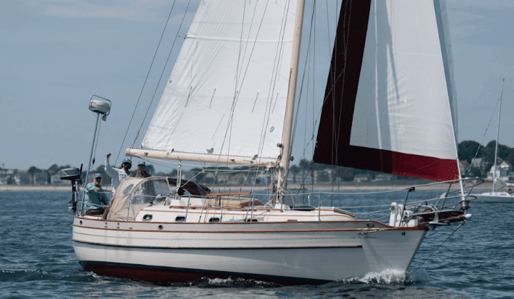 Sailboat cruising on calm waters near shore under blue sky, capturing the essence of maritime adventure and relaxation. regatta racing tips