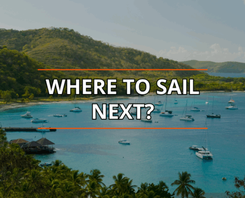 Tropical bay with anchored sailboats under clear sky, lush hills backdrop; text reads Where to Sail Next?