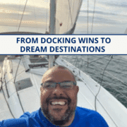 Smiling sailor on a sailboat at sea, enjoying a scenic cruise under a clear sky.