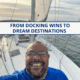 Smiling sailor on a sailboat at sea, enjoying a scenic cruise under a clear sky.