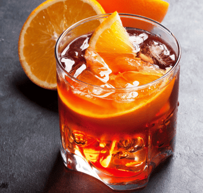 Chilled orange cocktail with ice, garnished with fresh orange slices, perfect for a sunset cruise refreshment.