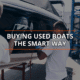 Two men inspecting a boat with 'Buying Used Boats The Smart Way' text overlay, showcasing careful evaluation.