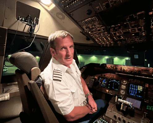 sa 744 oct 25 Pilot seated in airplane cockpit, night flight preparation, illuminated control panels.