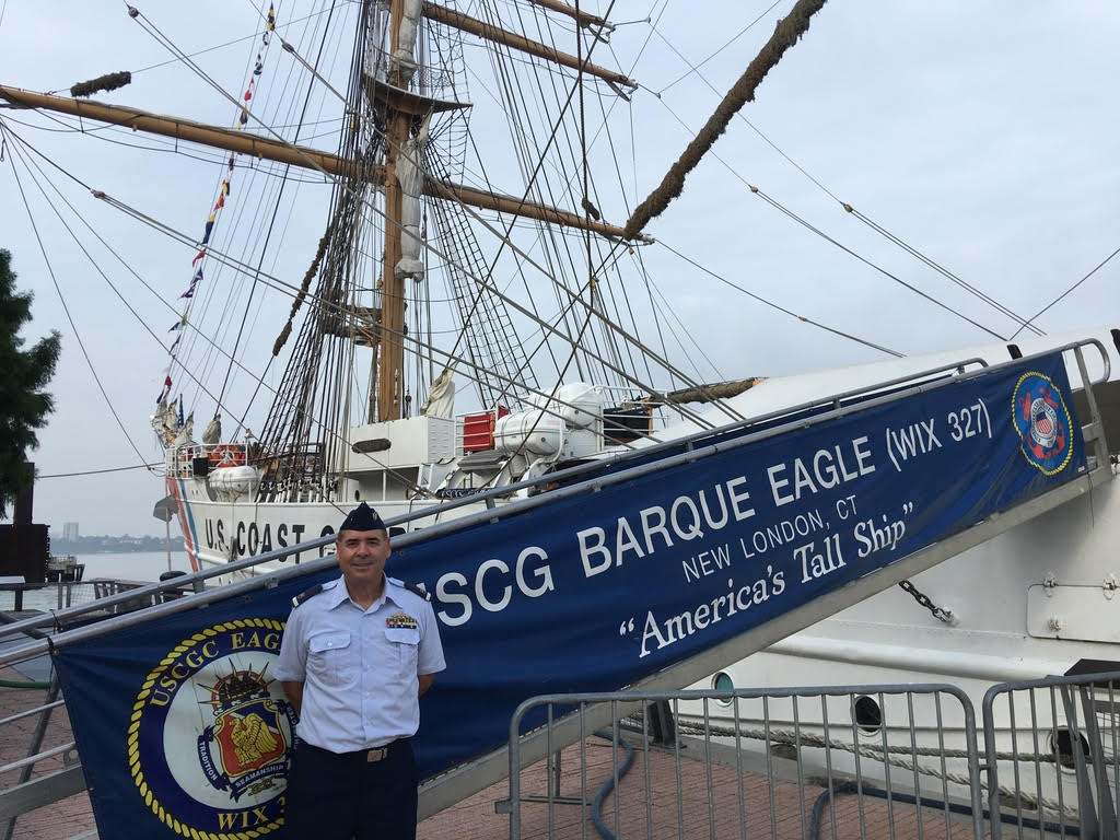 unnamed (1) USCGC Barque Eagle docked at New London, CT with a uniformed officer nearby, showcasing America's Tall Ship.