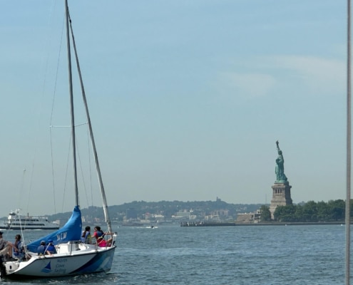Dave Stern Sailboat cruising by the Statue of Liberty on a clear day in New York Harbor.