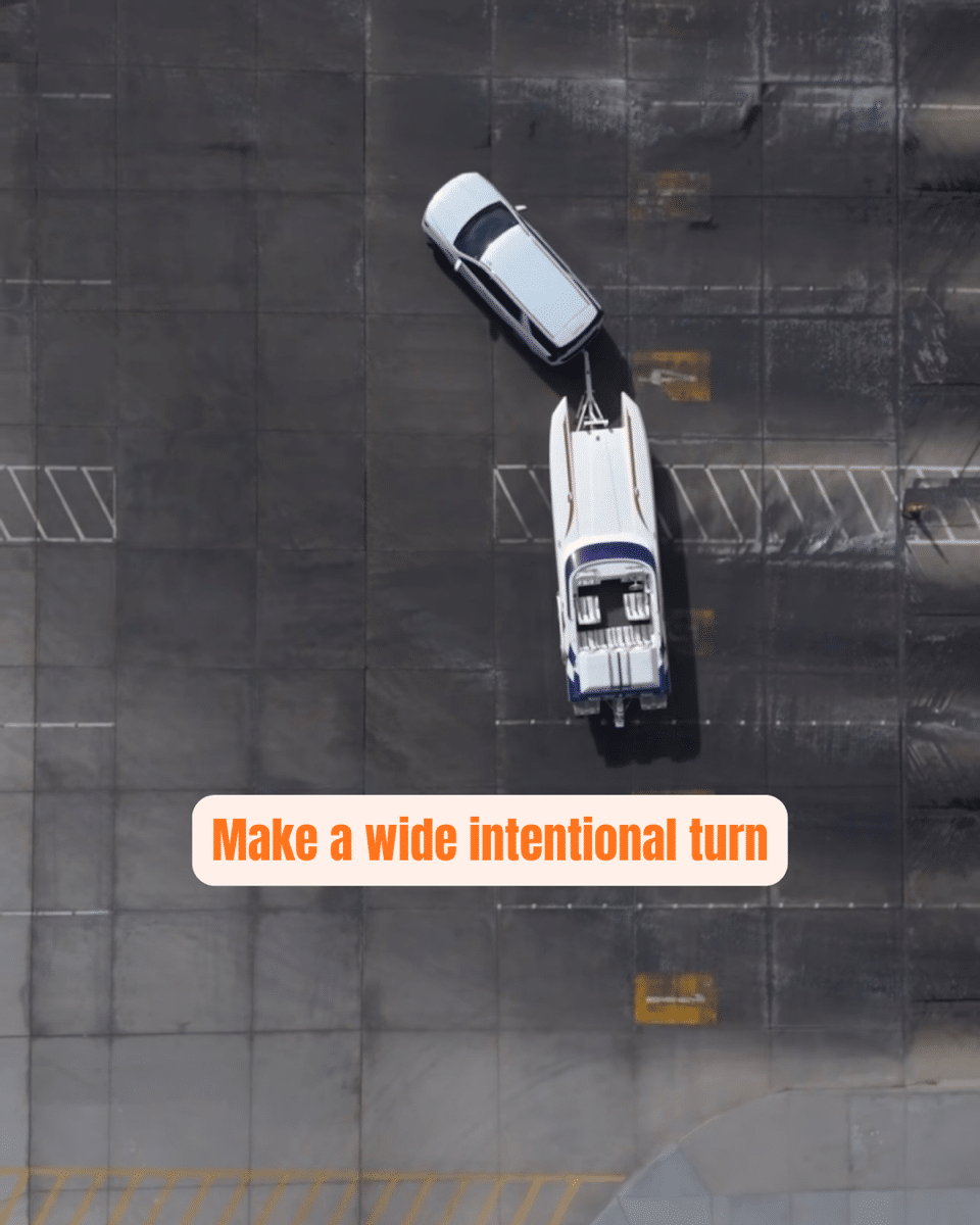 1 Car towing a boat makes a wide parking lot turn, emphasizing safe trailering techniques.