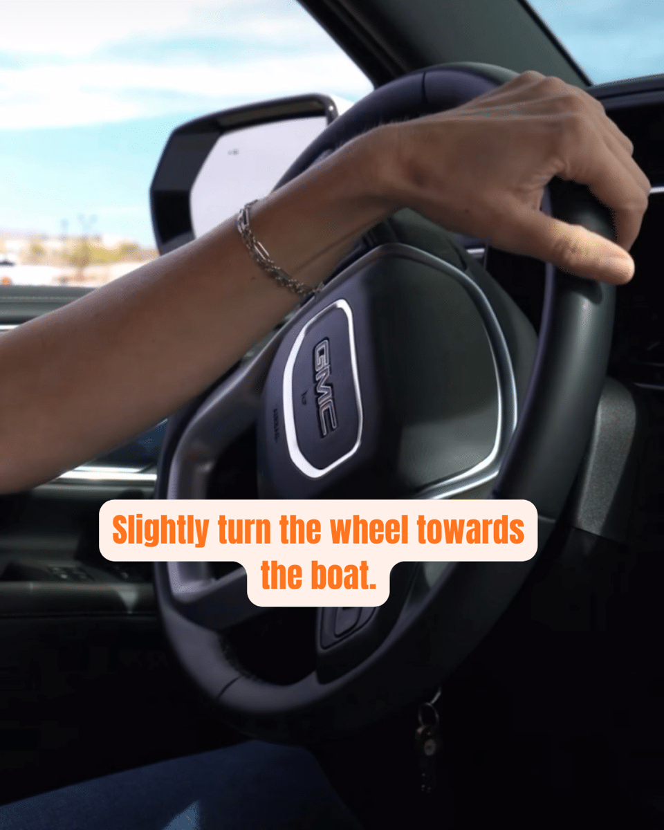 4 Turning steering wheel in GMC vehicle, text says: Slightly turn the wheel towards the boat.