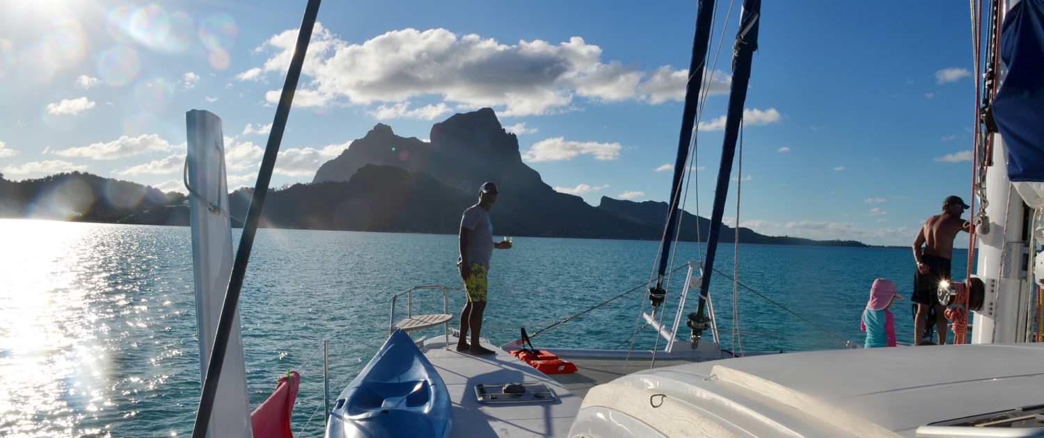 Sailing in tropical paradise with stunning mountain backdrop and clear blue waters. Perfect adventure getaway.