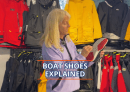 Woman explains features of boat shoes in a sailing gear shop.