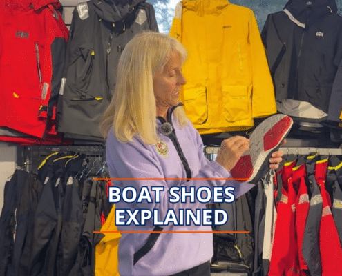 Woman explains features of boat shoes in a sailing gear shop.
