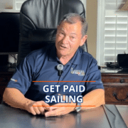 How to Make Money as a Sailing Instructor: 6 Real Income Streams Man in office chair discussing opportunities to earn money through sailing, wearing a Landfall Sailing polo.