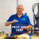 Man explaining boat propeller size considerations, standing in a workshop. Text: Prop Size Trap.