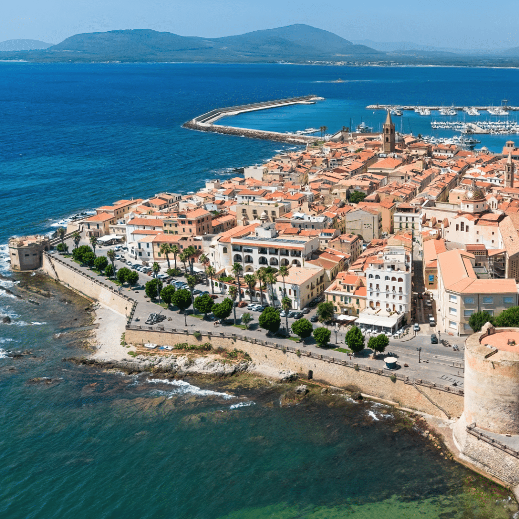 blog-below-deck-destinations-10-Catalan Coast Aerial view of a coastal city with a marina, fort, and vibrant blue sea, perfect for nautical adventures.