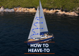 Sailboat demonstrating how to heave-to, with arrows on sails and scenic coastline background.