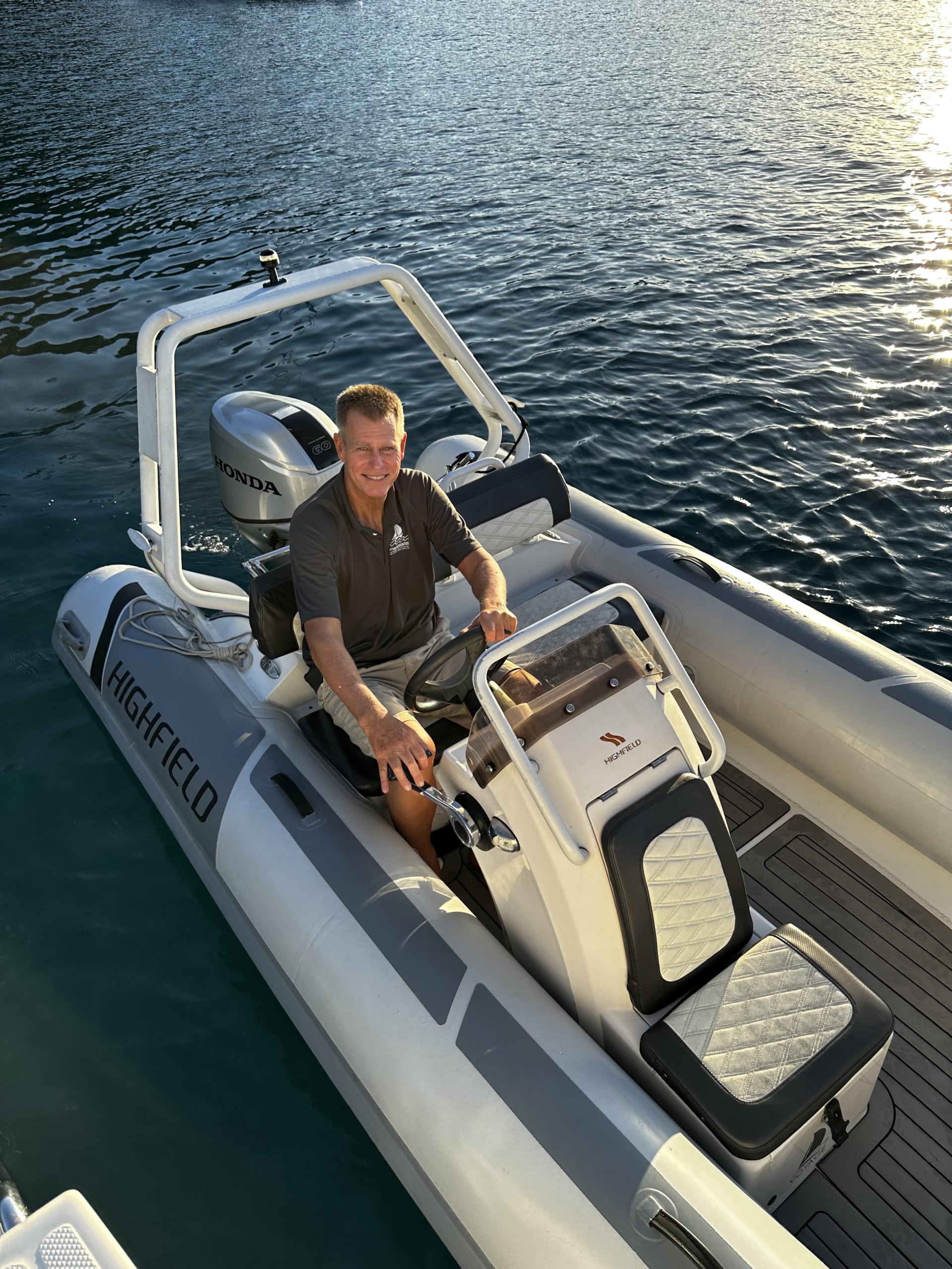 Bill Ibsen Man steering a RIB boat on calm waters, enjoying a sunny day at sea.