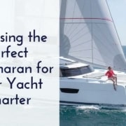 Catamaran sailing on the ocean with a person on deck; guide to choosing the perfect yacht charter.